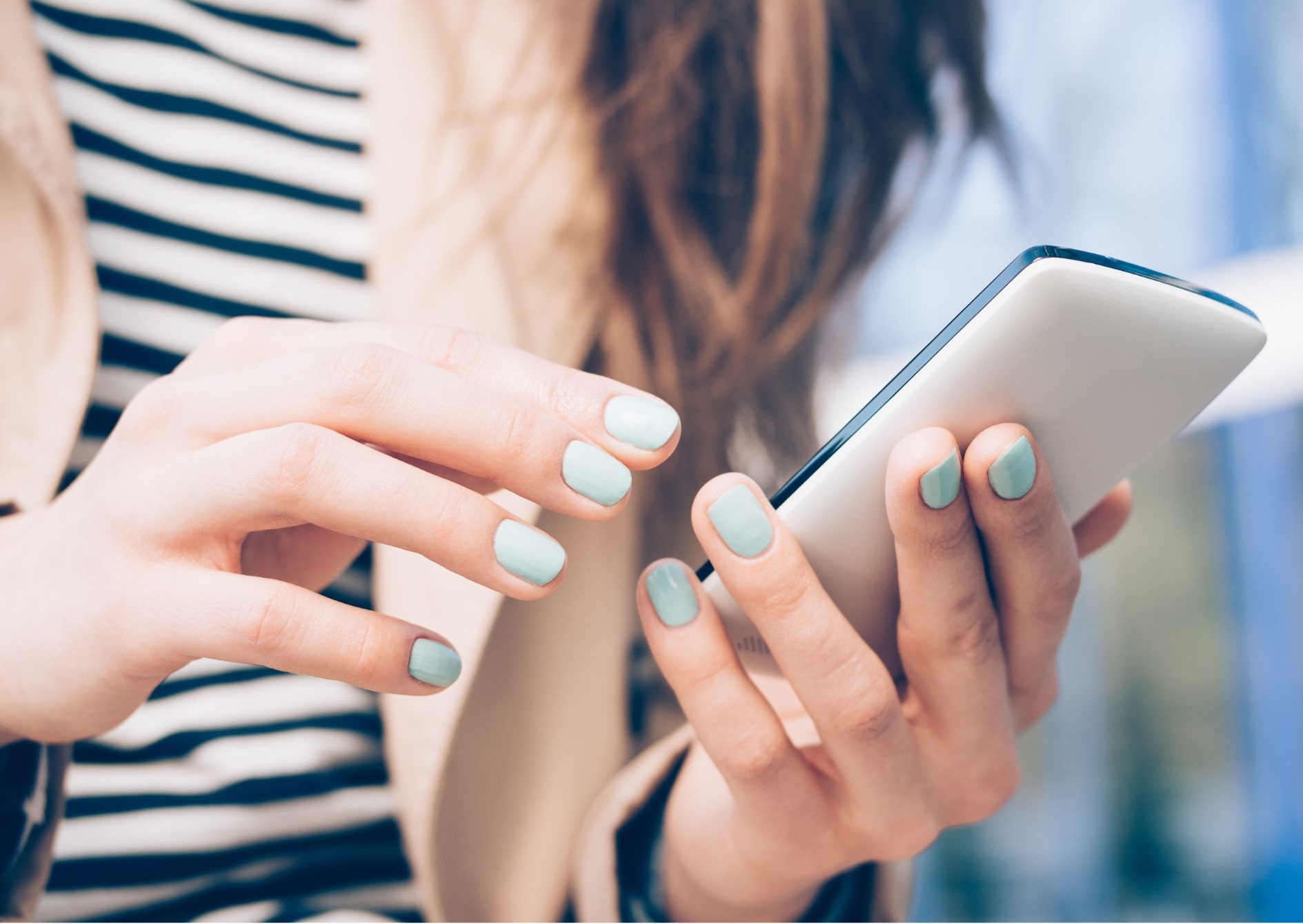 A woman's hands holding a cellphone