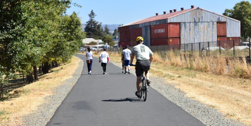 Bicyclists ride a paved trail in Napa Valley. 